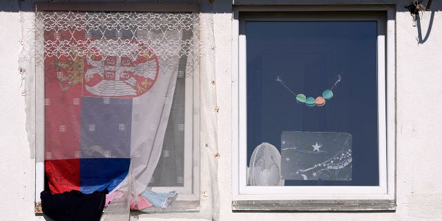 A Serbian flag is seen on a window in the Krnjaca refugee center near Belgrade, Serbia, Thursday, Feb. 24, 2022.