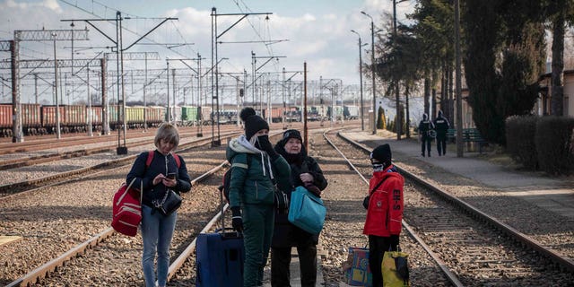 A family fleeing from Ukraine waits for the train at the border crossing station in Medyka, Poland, Thursday, March 10, 2022.