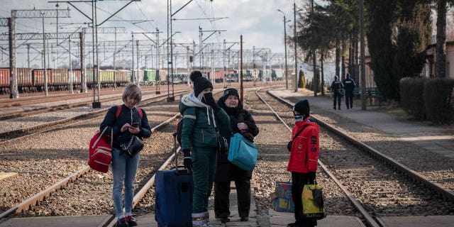 A family fleeing from Ukraine waits for the train at the border crossing station in Medyka, Poland, Thursday, March 10, 2022.