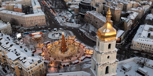 Snow covers the city center with a Christmas tree, St. Sophia Cathedral, foreground, and St. Michael Cathedral, background, in Kyiv, Ukraine, Tuesday, Dec. 21, 2021. 