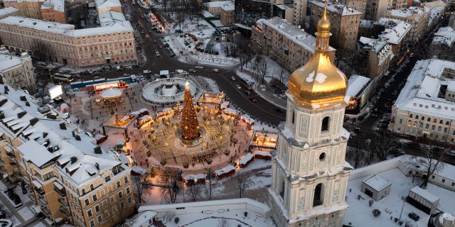Snow covers the city center with a Christmas tree, St. Sophia Cathedral, foreground, and St. Michael Cathedral, background, in Kyiv, Ukraine, Tuesday, Dec. 21, 2021.