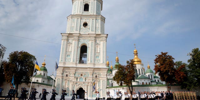 Ukrainian honor guard soldiers march past President Petro Poroshenko, background, in front of St. Sophia Cathedral in Kiev, Ukraine, Tuesday, Aug. 23, 2016, during State Flag Day celebrations. As the capital braces for a Russian attack in 2022, the spiritual heart of Ukraine could be at risk.
