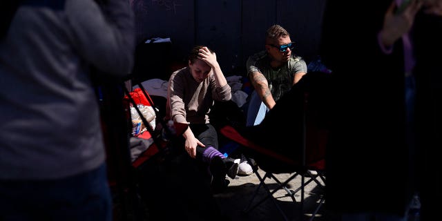 A couple from Russia seeking asylum in the U.S. wait in Tijuana, Mexico, Thursday, March 17, 2022.