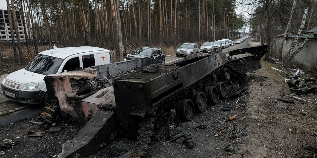 Could Putin get what he wants in Ukraine despite his military mess? Cars drive past a destroyed Russian tank as a convoy of vehicles evacuating civilians leaves Irpin, on the outskirts of Kyiv, Ukraine, March 9, 2022.