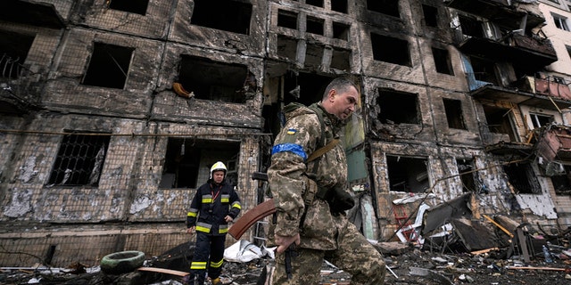 جنود ورجال إطفاء أوكرانيون يفتشون مبنى مدمرًا بحثًا عن هجوم بقنبلة في كييف ، أوكرانيا ، يوم الاثنين 14 مارس 2022 (AP Photo / Vadim Ghirda)