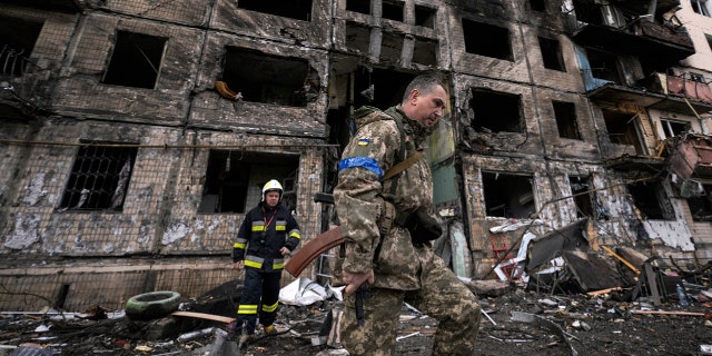 Soldados e bombeiros ucranianos vasculham um prédio destruído após um ataque a bomba em Kiev, Ucrânia, segunda-feira, 14 de março de 2022 (AP Photo/Vadim Ghirda)