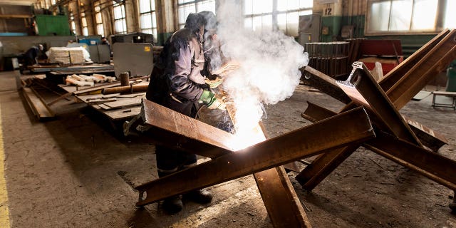 A worker welds metal inside the Interpipe Steel plant in Dnipro, Ukraine, March 10, 2022.