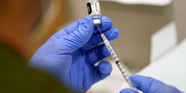 A health care worker fills a syringe with the Pfizer COVID-19 vaccine at Jackson Memorial Hospital on Oct. 5, 2021, in Miami.