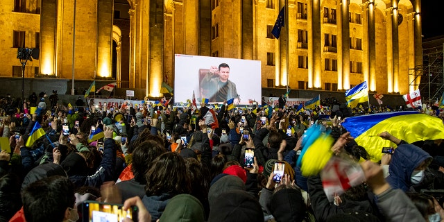 Ukrainian President Volodymyr Zelenskyy's speech is streamed live on a big screen in front of Parliament during a rally in support of Ukraine on March 4, 2022, in Tbilisi, Georgia.