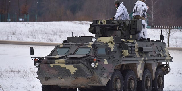 Ukrainian soldiers ride on top of the BTR-4 "Bucephalus" during a weapons training exercise on Feb. 4, 2022, in Lviv, Ukraine.