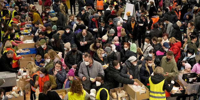 Ukrainian refugees queue for food in the welcome area after their arrival at the main train station in Berlin, Germany, March 8, 2022.