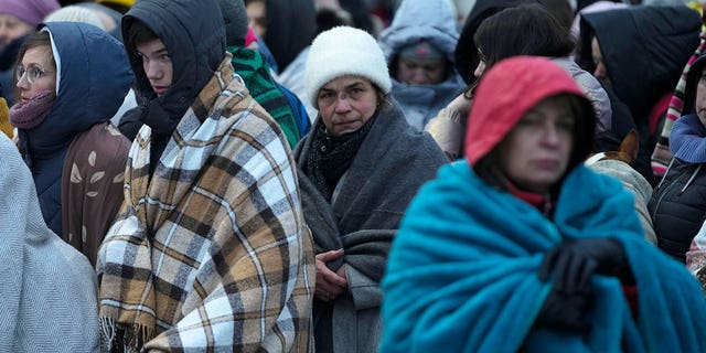Refugees, mostly women and children, wait in a crowd for transportation after fleeing from the Ukraine and arriving at the border crossing in Medyka, Poland, on March 7, 2022.