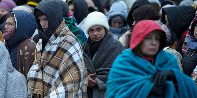 Refugees, mostly women and children, wait in a crowd for transportation after fleeing from the Ukraine and arriving at the border crossing in Medyka, Poland, on March 7, 2022.