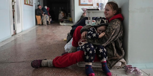 Anastasia Erashova cries as she hugs her child in a corridor of a hospital in Mariupol, eastern Ukraine on Friday, March 11, 2022. Anastasia's other child was killed during the shelling of Mariupol. (AP Photo/Evgeniy Maloletka)