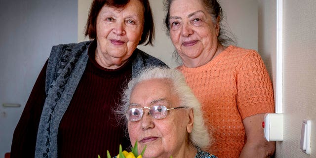Ukrainian Holocaust survivors Tatyana Zhuravliova, right, Larisa Dzuenko, left, and Galina Ulyanova pose for a photo during an AP interview in an old people's home in Frankfurt, Germany, Sunday, March 27, 2022.