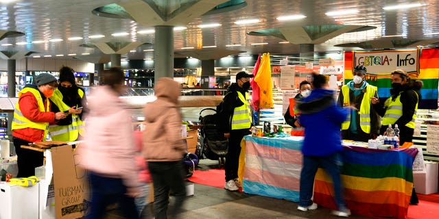 Volunteers waiting for refugees from Ukraine stand at information desks at the main train station in Berlin, Germany, Tuesday, March 15, 2022.