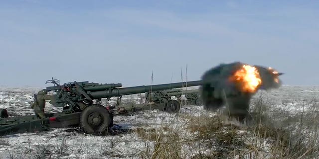 In this photo taken from video provided by the Russian Defense Ministry Press Service on Friday, Jan. 28, 2022, Russian troops fire howitzers during drills in the Rostov region during a military exercising at a training ground in Rostov region, Russia. 