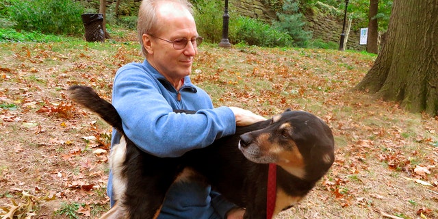 FILE - Actor William Hurt plays with his dog, Lucy, in Riverside Park in New York on Oct. 10, 2013.
