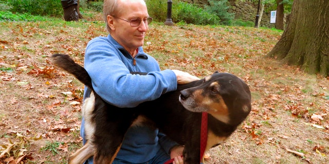 FILE - Actor William Hurt plays with his dog, Lucy, in Riverside Park in New York on Oct. 10, 2013.