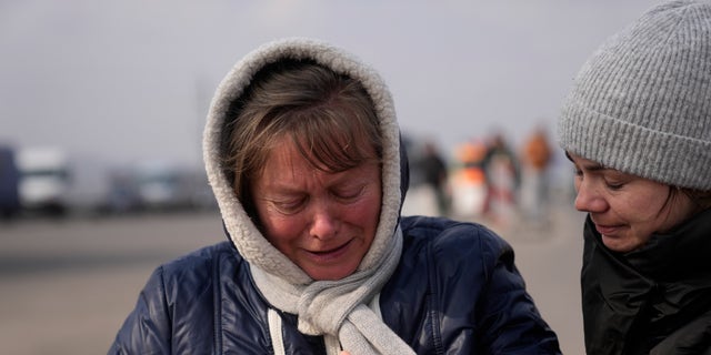 A woman fleeing from Ukraine is overcome by emotions at the border crossing in Medyka, Poland, Friday, March 4, 2022.