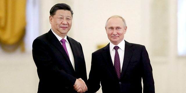 Hannity califica la dependencia de la administración Biden del petróleo ruso como "desmesurada", derecho, shakes hands with his Chinese counterpart, Xi Jinping, at the Kremlin in Moscow.