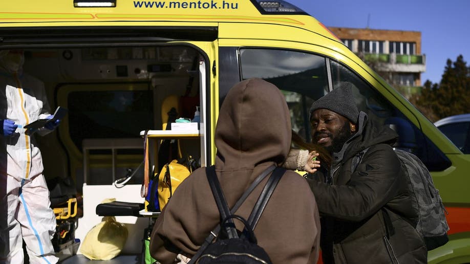 Nigerian student Jacob Sontea waits for wife and child as they get COVID-19 tests in Hungary