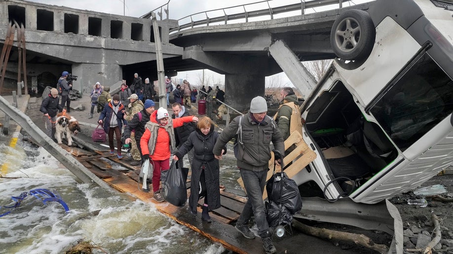 People cross path under destroyed bridge in Ukraine 