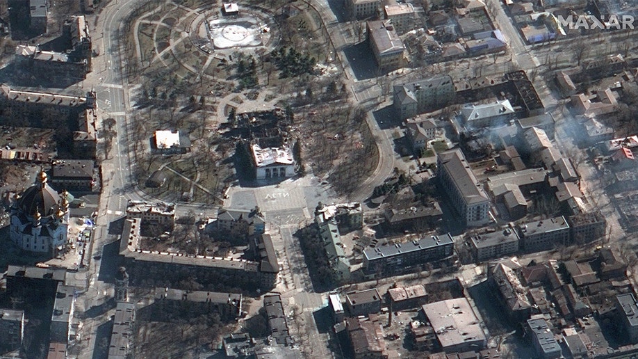 Satellite imagery captured by Maxar on Saturday, March 19, 2022, shows the aftermath of an airstrike on the Mariupol Drama Theater. The word "children" can be seen in white letters near the destroyed building.