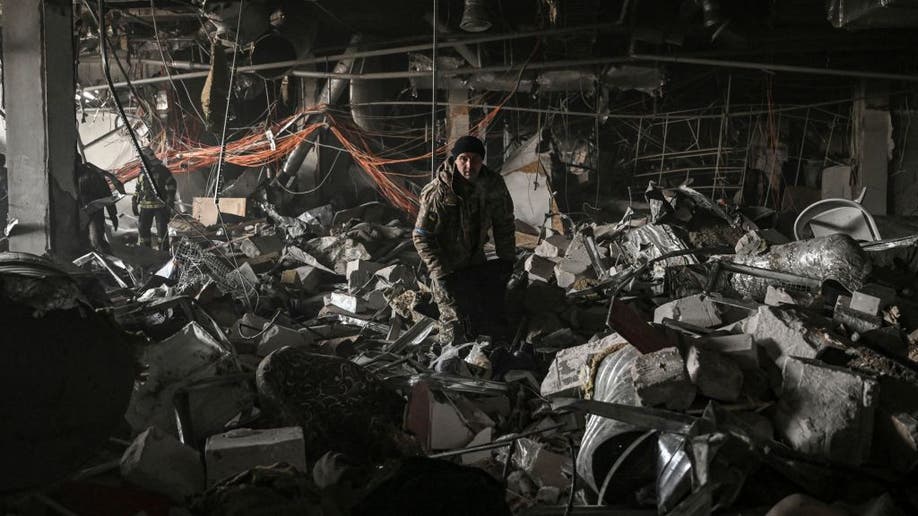 Ukrainian servicemen sift through rubble