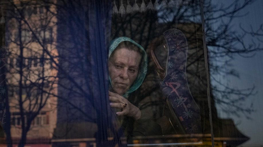 A woman stares out the window of a bus in Ukraine