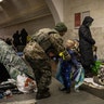 A Ukrainian soldier visits his son who is taking shelter in the lower level of a Kyiv metro station during Russian artillery strikes in Kyiv, Ukraine, on Wednesday, March 2, 2022.