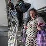 An injured pregnant woman walks downstairs in the damaged by shelling maternity hospital in Mariupol, Ukraine, Wednesday, March 9, 2022. A Russian attack has severely damaged a maternity hospital in the besieged port city of Mariupol, Ukrainian officials say.