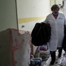 A medical worker walks inside of the damaged by shelling maternity hospital in Mariupol, Ukraine, Wednesday, March 9, 2022. A Russian attack has severely damaged a maternity hospital in the besieged port city of Mariupol, Ukrainian officials say.