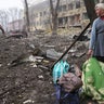 A woman walks outside the damaged by shelling maternity hospital in Mariupol, Ukraine, Wednesday, March 9, 2022. A Russian attack has severely damaged a maternity hospital in the besieged port city of Mariupol, Ukrainian officials say.