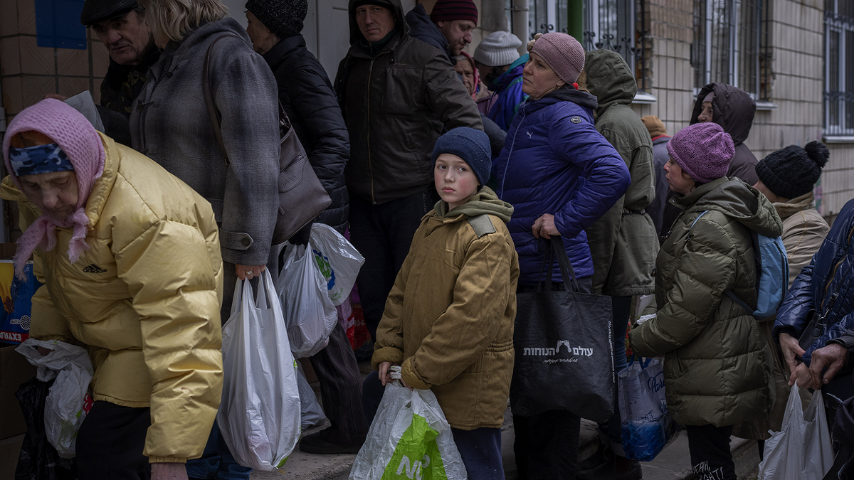 Sergei, 11, waits his turn to receive donated food during an aid humanitarian distribution in Bucha, in the outskirts of Kyiv, on Tuesday.