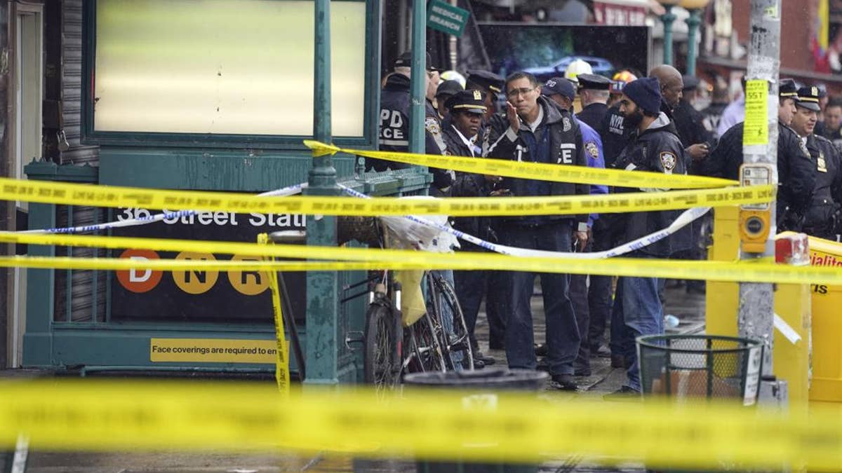 New York City Police Department personnel gather at the entrance to a subway stop in the Brooklyn borough of New York, Tuesday, April 12, 2022.