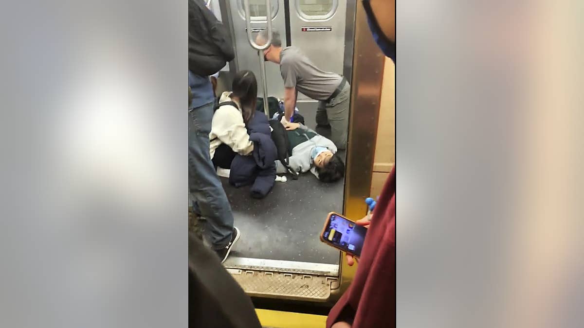 This photo provided by Will B Wylde, a person is aided in a subway car in the Brooklyn borough of New York, Tuesday, April 12, 2022.