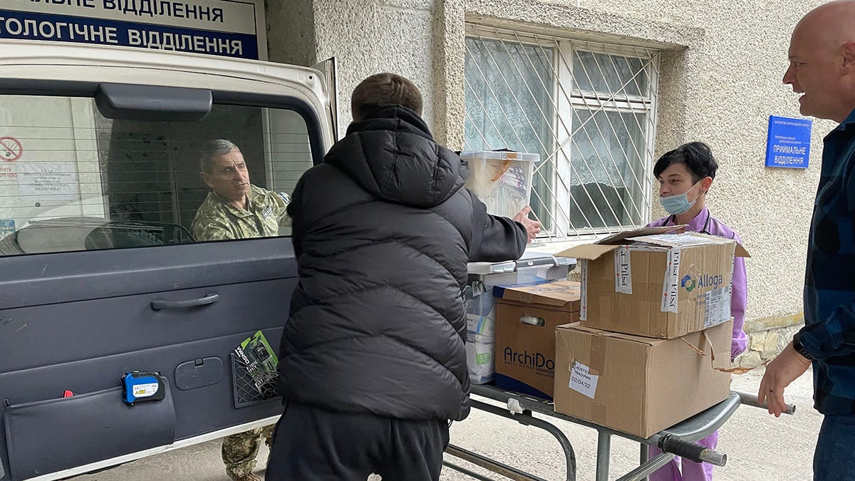 Dr. Daniel Smith assists with the unloading of medical supplies to a hospital in Ukraine. 