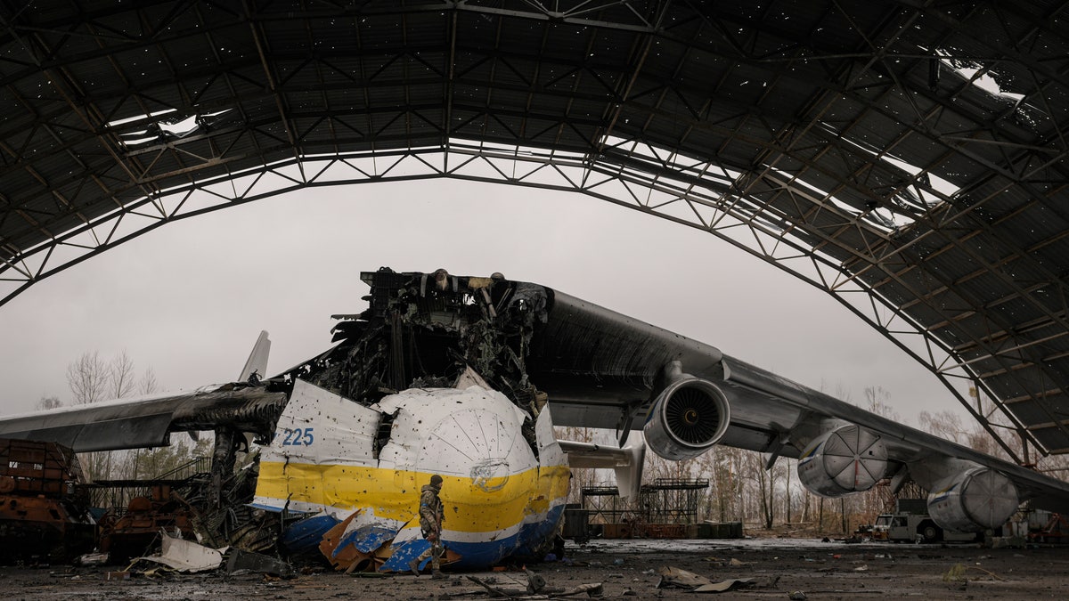 A Ukrainian serviceman walks by an Antonov An-225 Mriya aircraft destroyed during fighting between Russian and Ukrainian forces on the Antonov airport in Hostomel, Ukraine, Saturday, April 2, 2022.?