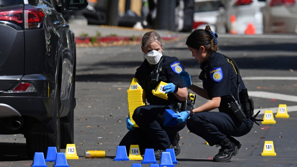 Sacramento Police crime scene investigators place evidence markers on 10th street at the scene of a mass shooting in Sacramento, Calif., on Sunday, April 3, 2022.  (Jose Carlos Fajardo/Bay Area News Group via AP)
