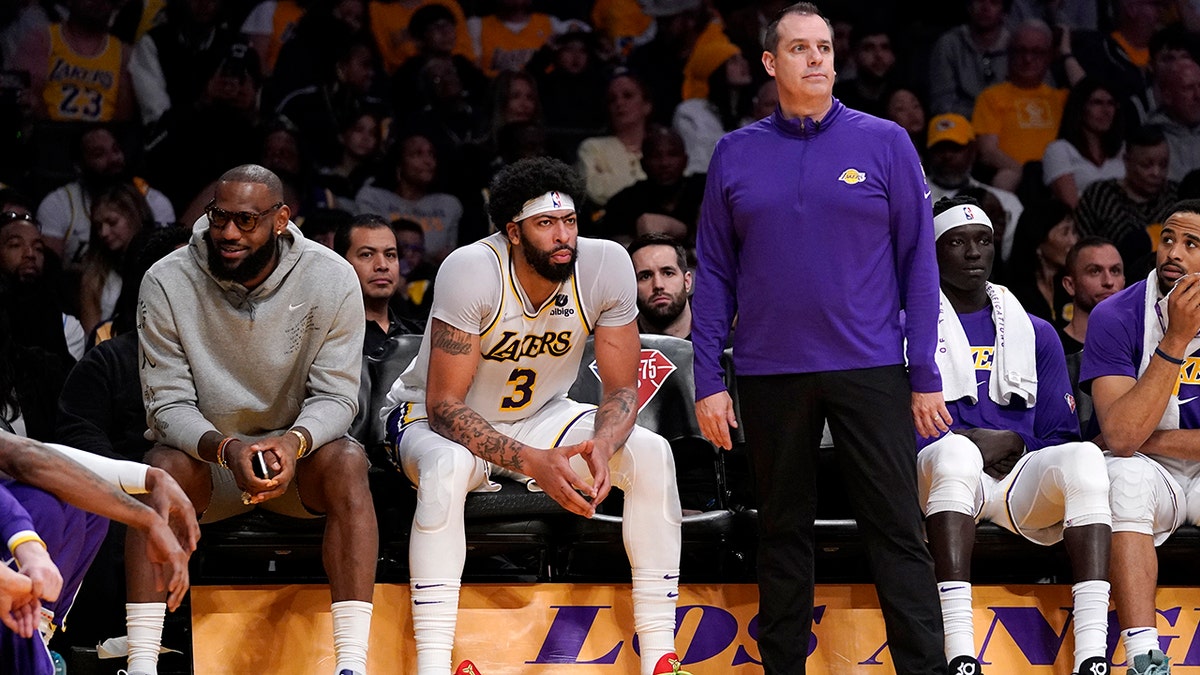 Los Angeles Lakers forward LeBron James, left, sits on the Bech next to forward Anthony Davis as head coach Frank Vogel stands by during the second half of an NBA basketball game against the Denver Nuggets Sunday, April 3, 2022, in Los Angeles.