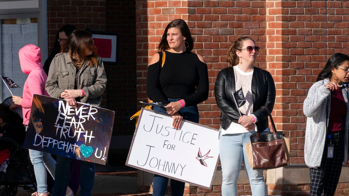 Supporters of actor Johnny Depp stand outside the Fairfax County Courthouse, Monday, April 11, 2022 in Fairfax, Va. Jury selection has begun in a long-anticipated libel lawsuit filed by Johnny Depp against his ex-wife, actress Amber Heard. 