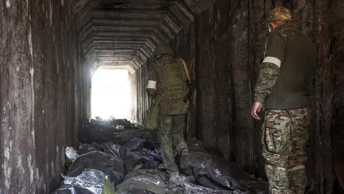 Servicemen of the Donetsk People's Republic militia look at bodies of Ukrainian soldiers placed in plastic bags in a tunnel, part of the Illich Iron &amp;amp; Steel Works Metallurgical Plant, the second largest metallurgical enterprise in Ukraine, in an area controlled by Russian-backed separatist forces in Mariupol, Ukraine, Monday, April 18, 2022. Mariupol, a strategic port on the Sea of Azov, has been besieged by Russian troops and forces from self-proclaimed separatist areas in eastern Ukraine for more than six weeks.?