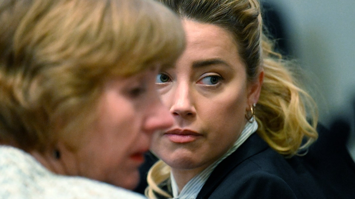 Attorney Elaine Bredehoft (L) and US actress Amber Heard look on during a trial in the Fairfax County Circuit Courthouse in Fairfax, Virginia, on April 19, 2022. - US actor Johnny Depp is suing ex-wife Amber Heard for libel after she wrote an op-ed piece in The Washington Post in 2018 referring to herself as a ìpublic figure representing domestic abuse.