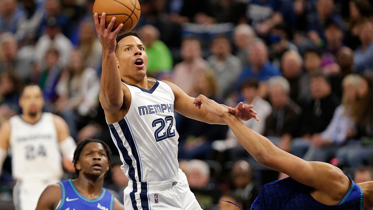 Memphis Grizzlies guard Desmond Bane (22) shoots as Minnesota Timberwolves center Karl-Anthony Towns, right, defends and forward Anthony Edwards watches during the first half of Game 3 of an NBA basketball first-round playoff series Thursday, April 21, 2022, in Minneapolis.