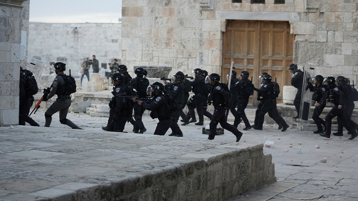 Israeli police enter the Al Aqsa Mosque compound where they clashed with Palestinian protesters following early morning prayers in Jerusalem's Old City, Friday, April 22, 2022.