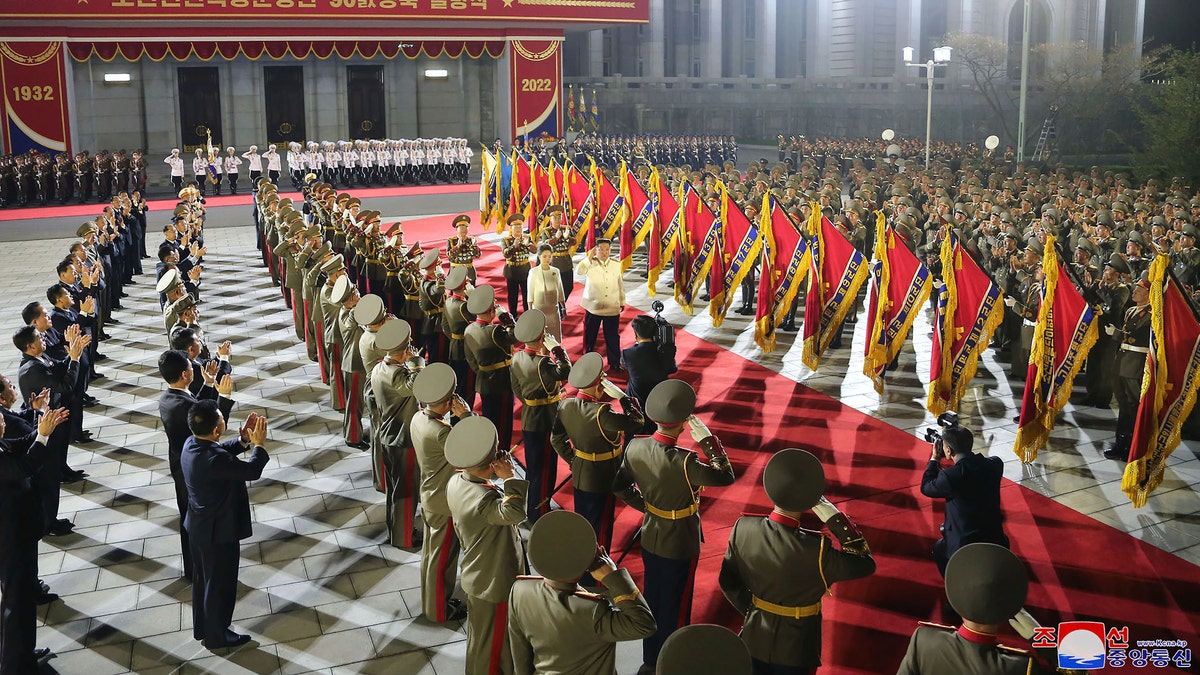 In this photo provided by the North Korean government, North Korean leader Kim Jong Un, center, with his wife Ri Sol Ju reviews an honor guard during a military parade to mark the 90th anniversary of North Korea's army at the Kim Il Sung Square in Pyongyang, North Korea Monday, April 25, 2022. (Korean Central News Agency/Korea News Service via AP)