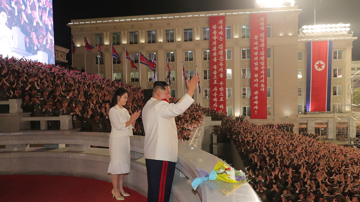 In this photo provided by the North Korean government, North Korean leader Kim Jong Un, with his wife Ri Sol Ju, acknowledges the audience during a military parade to mark the 90th anniversary of North Korea's army at the Kim Il Sung Square in Pyongyang, North Korea Monday, April 25, 2022. (Korean Central News Agency/Korea News Service via AP)
