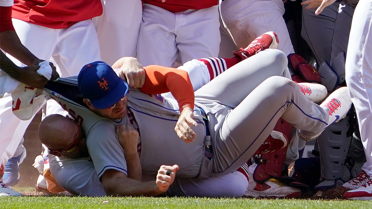 New York Mets' Pete Alonso is taken to the ground by St. Louis Cardinals first base coach Stubby Clapp during an eighth-inning scuffle Wednesday, April 27, 2022, in St. Louis.