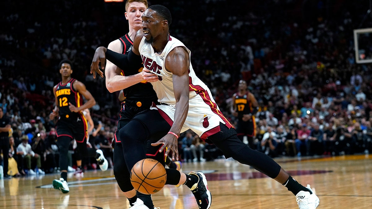 Miami Heat center Bam Adebayo, right, drives to the basket as Atlanta Hawks guard Kevin Huerter defends during the second half of an NBA basketball game Friday, April 8, 2022, in Miami. The Heat won 113-109.